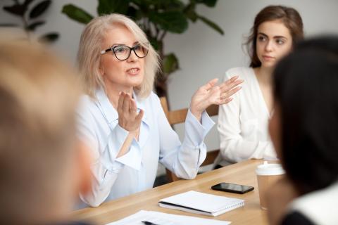 Attraktive Frau mittleren Alters erläutert ihrem Team einen Sachverhalt. Attraktive Frau mittleren Alters erläutert ihrem Team einen Sachverhalt.