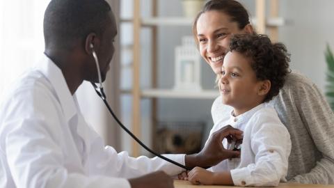 Arzt im Krankenhaus hört ein kleines Kind ab