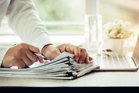 Fachkraft sortiert im Home-Office Unterlagen