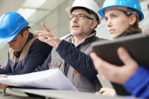 Ingenieurin erläutert Pläne auf einer Baustelle