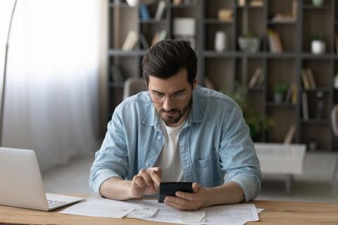 Interessierter Bewerber informiert sich am Smartphone über Einstellungsbedingungen in seinem Bundesland