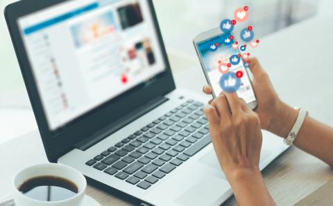 Person hält Smartphone und erhält viele Likes auf einen Beitrag
