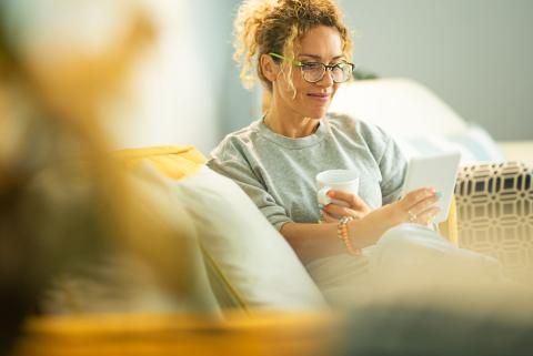 Weibliche Führungskraft liest ein eBook und trinkt einen Kaffee