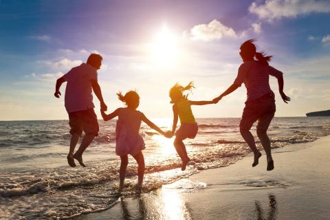 Mutter, Vater und zwei Kinder am Strand