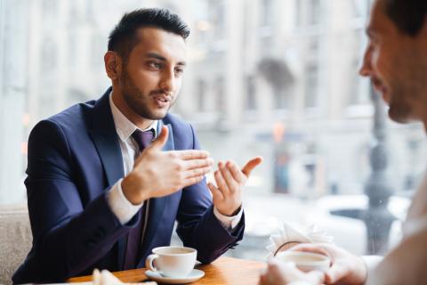 Angestellter Experte eines Ministeriums erklärt etwas in der Kaffeepause