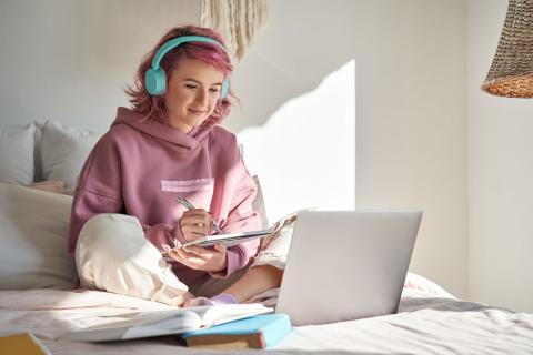 Junge Frau mit pinken Haaren arbeitet zuhause